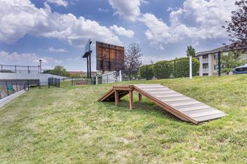 A wooden ramp leads to a picnic table in a grassy area.